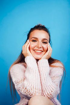 young pretty modern hipster girl posing emotional happy on blue background, lifestyle people concept close up