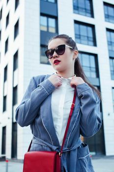young pretty brunette business woman posing against modern building in glasses holding coffee, lifestyle people concept close up