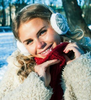 young pretty teenage hipster girl outdoor in winter snow park having fun drinking coffee, warming up happy smiling, lifestyle people concept close up