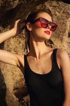 woman in black swimsuit summer posing rocks. High quality photo