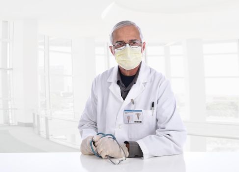 Medical Professional wearing a surgical mask, gloves and holding a stethoscope in a modern office setting. ID Badge is computer generated.