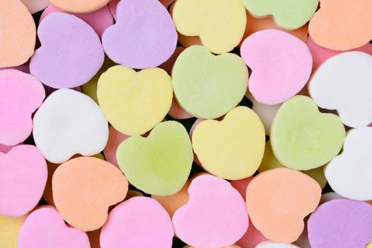 Macro shot of pastel candy hearts for Valentine's Day. The hearts are all bland and ready for your message.
