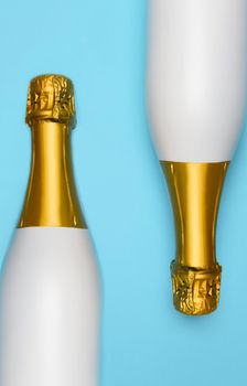 Two White Champagne bottle on a blue teal background. Vertical High angle shot. 