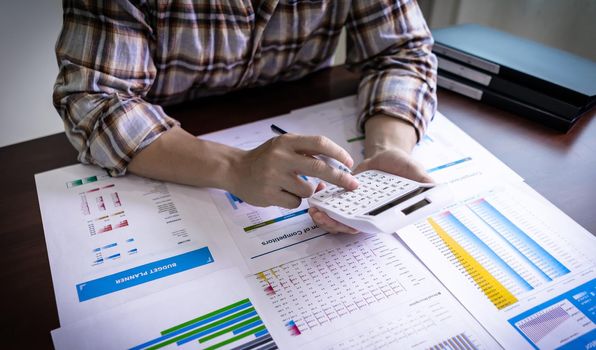 An accountant is using a calculator to calculate financial accounts, income and loss statistics, company earnings. Accountant and business concept.