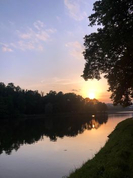 Dramatic sunset clouds over lake and trees - stock photo. High quality photo