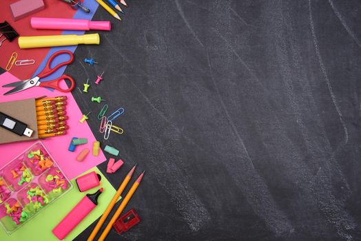 School Supplies: Still life on erased Chalkboard of assorted school supplies with copy space.