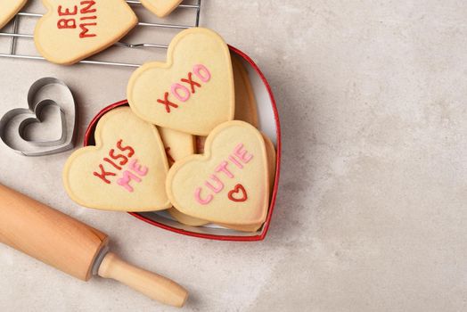 Valentines Day Concept: Heart shaped sugar cookies in a heart shaped box with cooling rack and rolling pin, with copy space.
