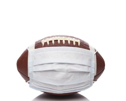 Sports and Covid-19 Concept.  An american Foortball with a surgical mask. 