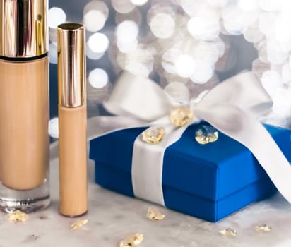 Cosmetic branding, Christmas glitter and girly blog concept - Holiday make-up foundation base, concealer and blue gift box, luxury cosmetics present and blank label products for beauty brand design