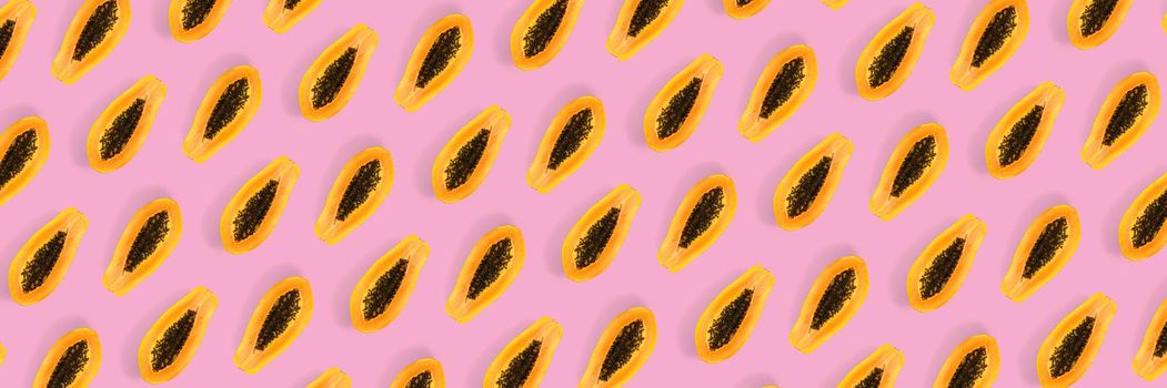 Fresh ripe papaya background on pink backdrop. Modern tropical abstract background. Top view. Creative design, minimal flat lay concept. Trend tropical fruit food background - not seamless pattern