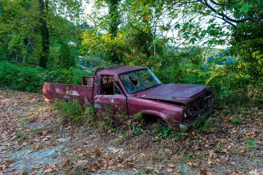 Old crashed car in the forest, Greece