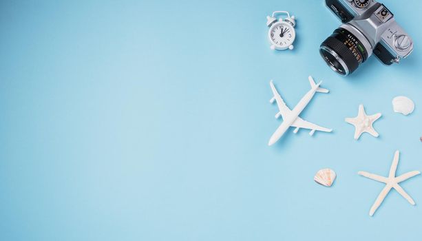 Flat lay top view mockup retro camera films, airplane, starfish, shells traveler tropical accessories isolated on a blue background with copy space, Business trip, and vacation summer travel concept