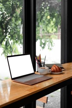 Workplace, laptop computer with blank empty white screen display monitor on desk. Mock up, Home office concept. Business, working from home, studying, e-learning at morning.