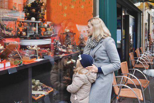 Girl with mother looking at the Christmas showcase