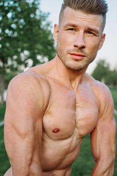 sporty muscled man with naked torso in a workout park. High quality photo