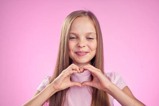 cute girl with long hair on pink background lifestyle childhood. High quality photo