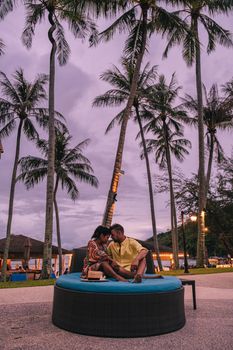 Luxury swimming pool with palm trees at night during sunset in Thailand. Sunset tropical beach with palm trees