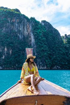 Maya Bay Koh Phi Phi Thailand, Turquoise clear water Thailand Koh Pi Pi, Scenic aerial view of Koh Phi Phi Island in Thailand. Asian woman mid age with hat in longtail boat