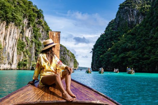 Maya Bay Koh Phi Phi Thailand, Turquoise clear water Thailand Koh Pi Pi, Scenic aerial view of Koh Phi Phi Island in Thailand. Asian woman mid age with hat in longtail boat