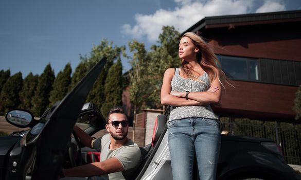 young couple standing near luxury car.the concept of a successful lifestyle