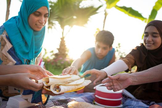 Happy family enjoying picnic on beach near sea