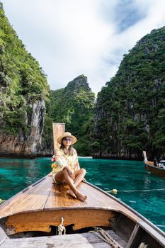 Maya Bay Koh Phi Phi Thailand, Turquoise clear water Thailand Koh Pi Pi, Scenic aerial view of Koh Phi Phi Island in Thailand. Asian woman mid age with hat in longtail boat