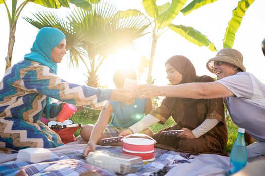 Happy family enjoying picnic on beach near sea