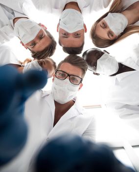 Surgeons in operating theatre looking down at patient, personal perspective