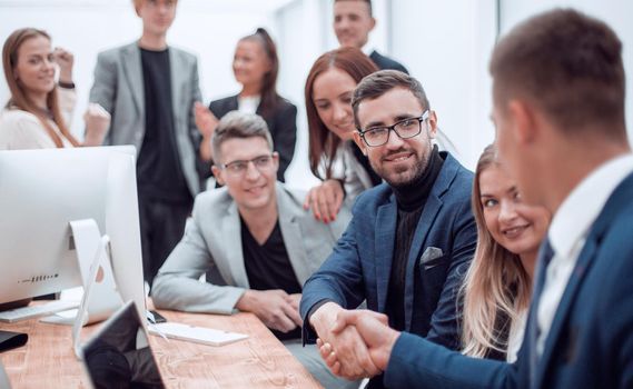 business people shaking hands sitting at the office Desk. the concept of cooperation