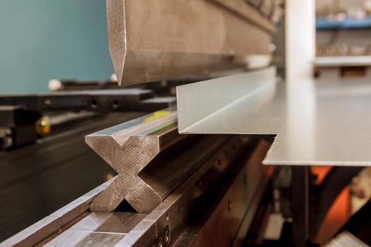 Bending sheet metal with a hydraulic bending machine at the factory.