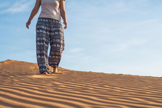 young woman in rad sandy desert at sunset or dawn