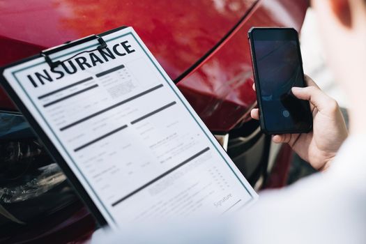 Man agent takes a snapshot of the damaged car and examines it, Traffic Accident and insurance concept.