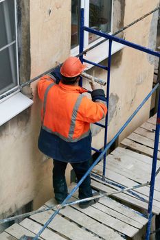 Saint Petersburg, Russia - April 24, 2021: Workers erect scaffolding to repair the facade of a building