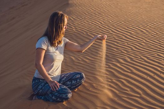 young woman in rad sandy desert at sunset or dawn