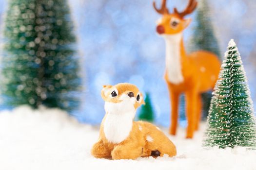 greeting new year card, two little toy deer in the snow.