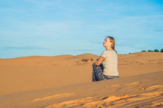 young woman in rad sandy desert at sunset or dawn