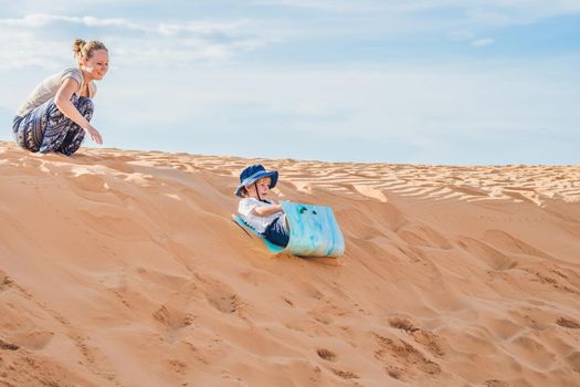 Fit mother with son running at the desert in Gran Canaria, Maspalomas on sunset.