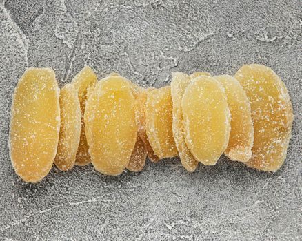 Sweet and spicy candied ginger on a grey concrete background