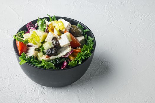 Greek salad with fresh vegetables, feta cheese and olives kalamati, on white background with copy space for text