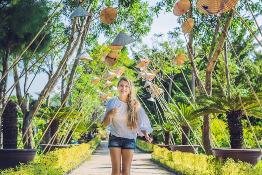 Young woman tourist and Vietnamese hats. Travel around Vietnam concept.