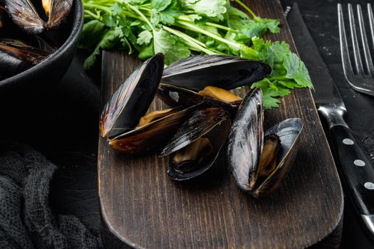 Boiled mussels with cheese sauce and garlic sauce, in bowl, on black background