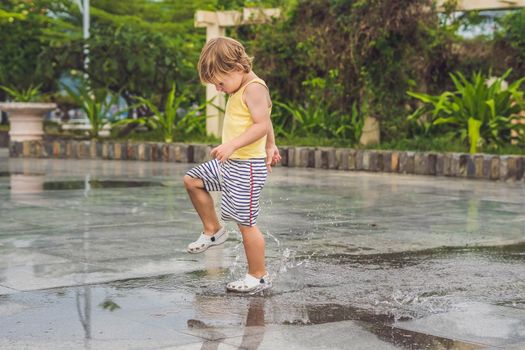 Little boy runs through a puddle. summer outdoor.