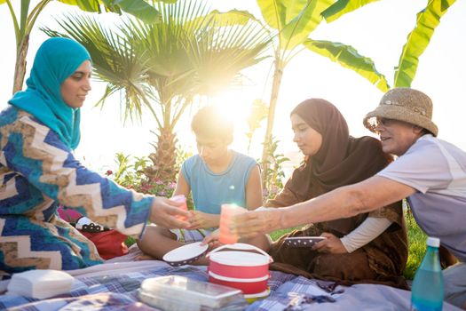 Happy family enjoying picnic on beach near sea