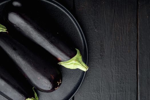 Fresh raw Purple Eggplant set, on black wooden table background, top view flat lay, with copy space for text