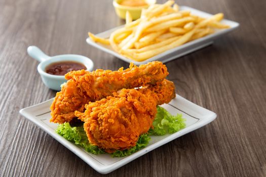 crispy and golden fried chickens with sauce on wooden table