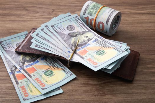 US Dollar bills stack on wooden table