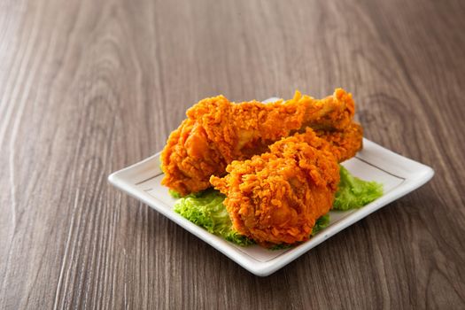 crispy and golden fried chickens with sauce on wooden table