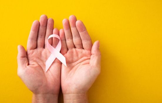 Breast Cancer concept : Woman hands and supporting Pink ribbon symbol of breast cancer