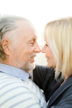 Close up photo of elderly caucasian couple toching noses. Concept of relationship and love.