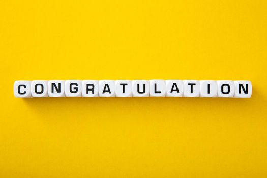 White block with congratulations word on yellow background